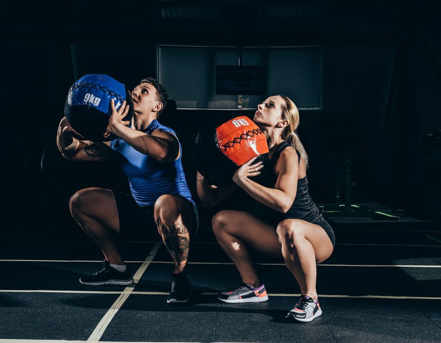 young-athletic-man-and-woman-squatting-with-weight-2024-11-18-03-51-08-utc